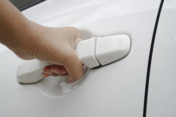 女人的手打开白色的车门。关闭了。图片下载