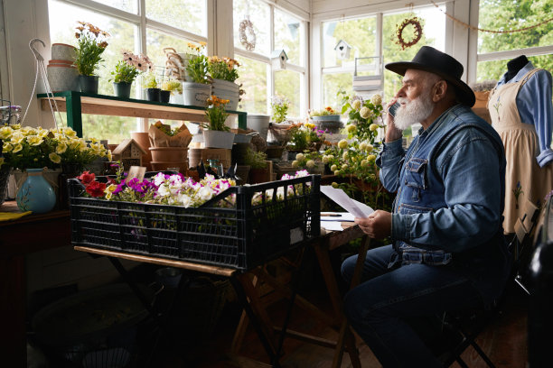 一位老人在花店打电话谈生意图片下载