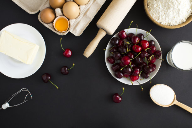 制作樱桃派或蛋糕的原料在黑色背景上的俯视图。副本的空间。图片下载