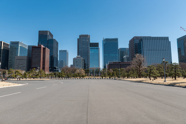 东京城市景观在背景和公园在前景与道路和摩天大楼与晴朗的蓝天。日本。靠近皇宫图片下载