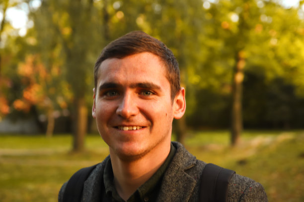 自然秋景背景下的青年肖像散焦。微笑的年轻人。20年。帅哥户外肖像。走在公园里。的生活方式。学生。秋天的人。的焦点图片下载