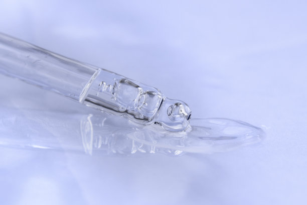 带液体透明质酸的移液器，单色蓝色背景。化妆品和保健概念特写图片下载