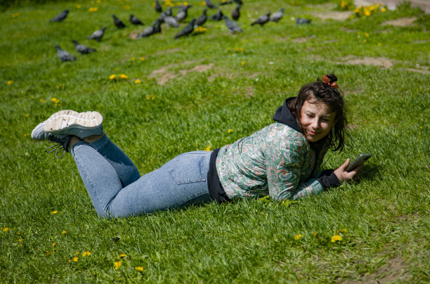 年轻女子躺在草地上图片下载