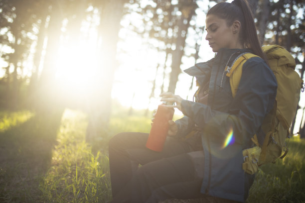 登山运动员坐在树桩上休息。图片下载