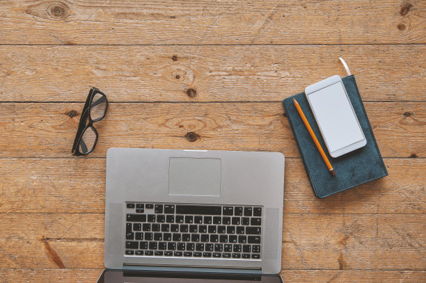 笔记本电脑、纸质笔记本、智能手机和眼镜放在木地板上图片下载