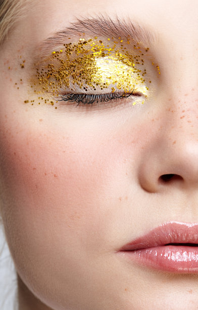 特写微距拍摄人类女性的脸与黄色烟熏妆。图片下载