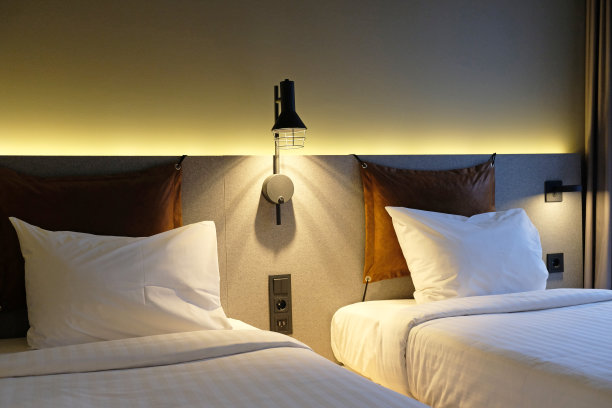 现代卧室室内设计家居或酒店。卧室的碎片，空着的床头柜，阅读灯和充电的USB插座。柔软的枕头和毯子，时尚舒适的家具。图片下载