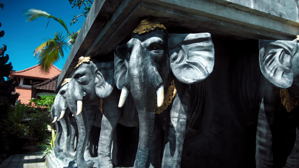 戴着帽子、举着混凝土板的大象雕像图片下载