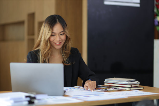 商务女性工作或秘书的肖像与笔记本电脑和财务文件在办公室的桌子上。图片下载