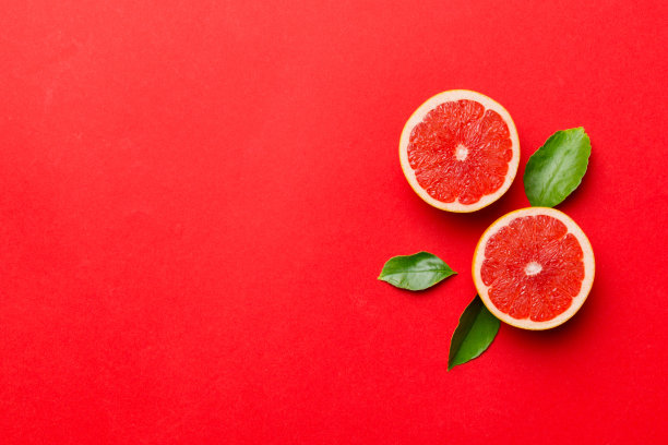 新鲜的柚子配多汁的柚子片。前视图。副本的空间。创造性的夏天的概念。一半柑橘在最小的平面铺设复制空间图片下载