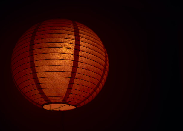 黑色背景上一个红色中国纸灯笼的特写图片下载