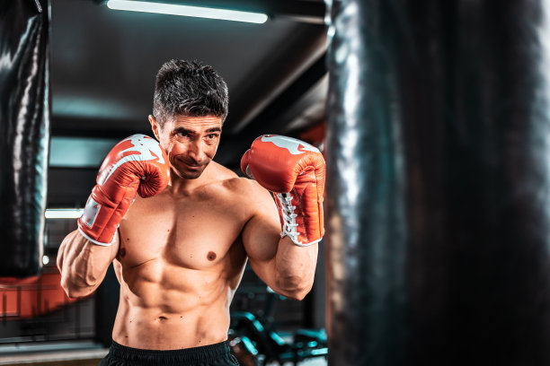 中年强壮的运动男子拳击手在健身房锻炼的照片，看向一边。图片下载