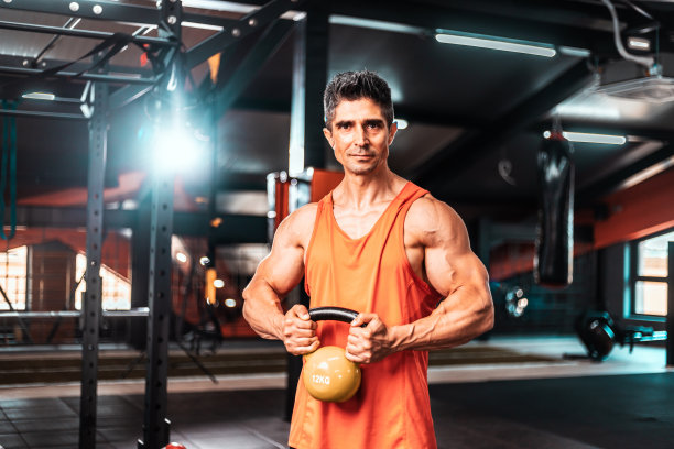 运动男子摆壶铃。男子在健身房的照片。健美运动员的肖像。力量和动力图片下载