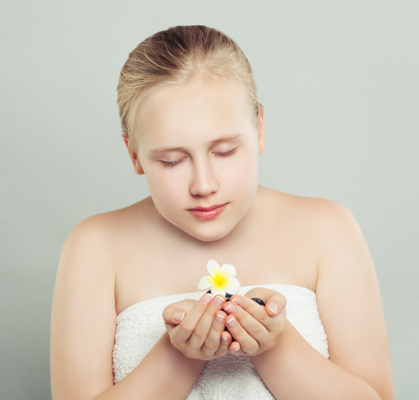 年轻完美的少女享受花。水疗美容、香薰、养生、面部护理、护肤理念图片下载