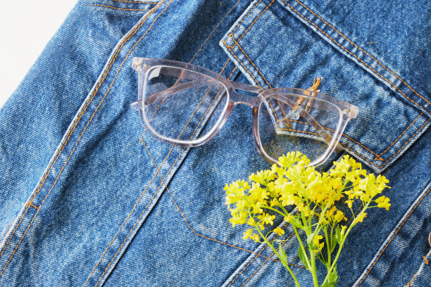 蓝色牛仔夹克口袋上的野花和透明边框眼镜，潮流眼镜，复古风格图片下载
