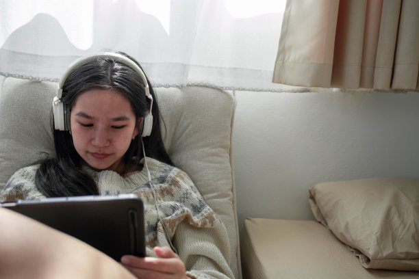 女人躺在沙发上玩iPad图片下载