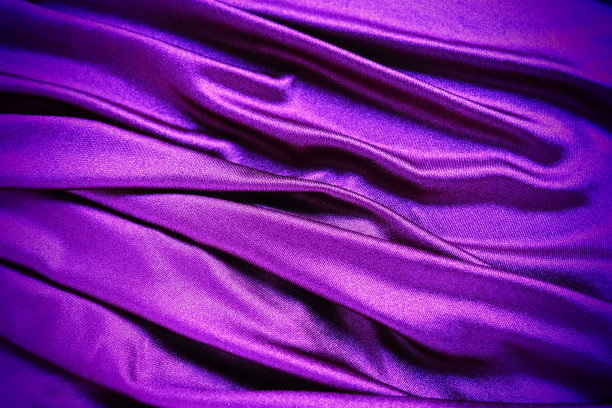 丝绒织物，类似丝绸纺织品的褶皱和美丽的波浪。窗帘上有紫色，粉色，品红色。晚礼服、家具、室内装饰、窗帘、室内装饰的缝纫材料图片下载