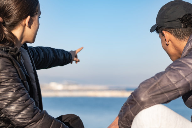 一对夫妇喜欢看海。后面的观点。专注于前景。图片下载