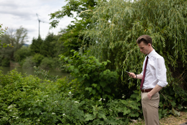 一个留着小胡子的年轻潮人在城市公园散步图片下载
