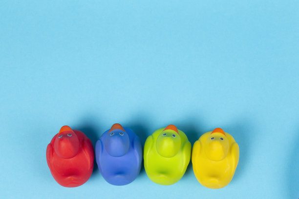 多色橡胶鸭从上面拍摄的蓝色背景。图片下载