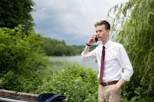 一个留着小胡子的年轻潮人在城市公园散步图片下载