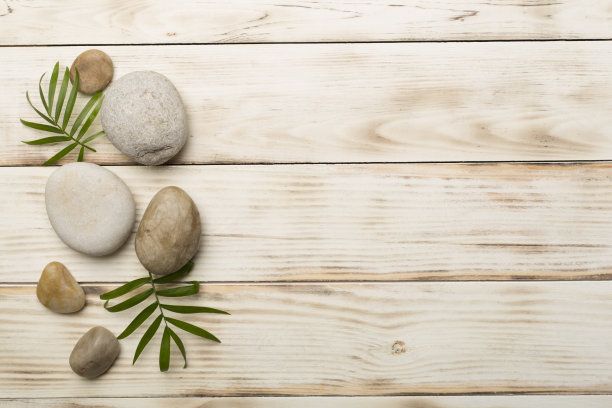 木制背景上的温泉石和树叶，俯视图图片下载