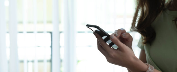 横向概念照片的女人。近距离手持使用智能手机应用程序交流在线浏览互联网，横幅为网站标题设计与文本的复制空间图片下载