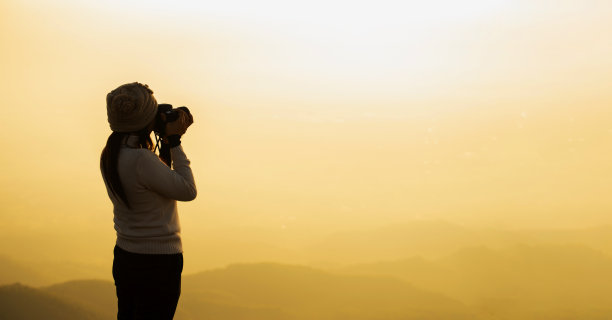 剪影亚洲女性自然摄影师，美丽的背景在日落图片下载