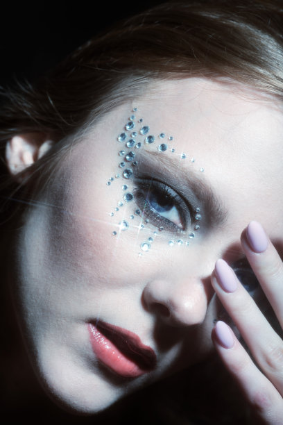 美丽的女人肖像与粘在她的脸上的珠宝图片下载