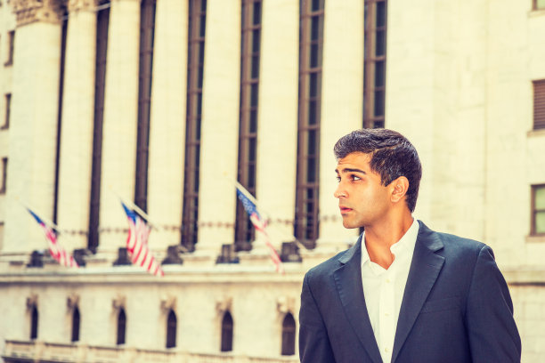 一个年轻人站在纽约市的办公楼外图片下载