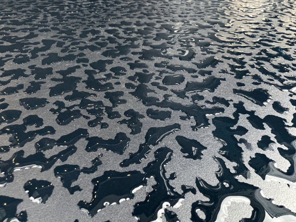 雨滴在黑色的桌子表面，形成一些抽象的概念背景图片下载