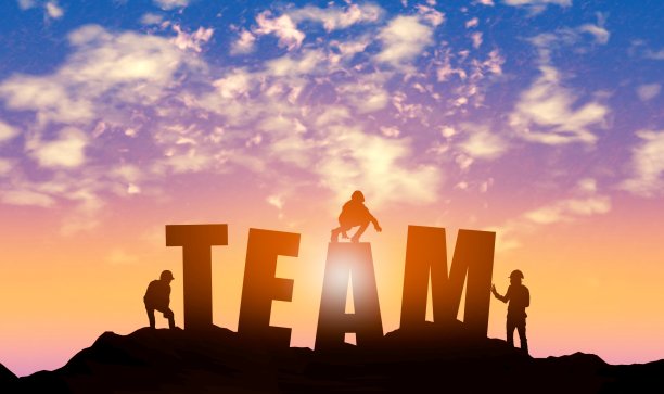 日落天空背景下团队合作的剪影图片下载