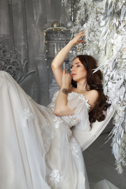 浪漫的女子新娘穿着白色的婚纱在家里等待着婚礼。华丽的室内，新娘的早晨图片下载