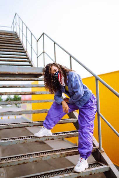 街头舞者穿着时髦的衣服，用美国大手帕跳舞，展示一些动作图片下载