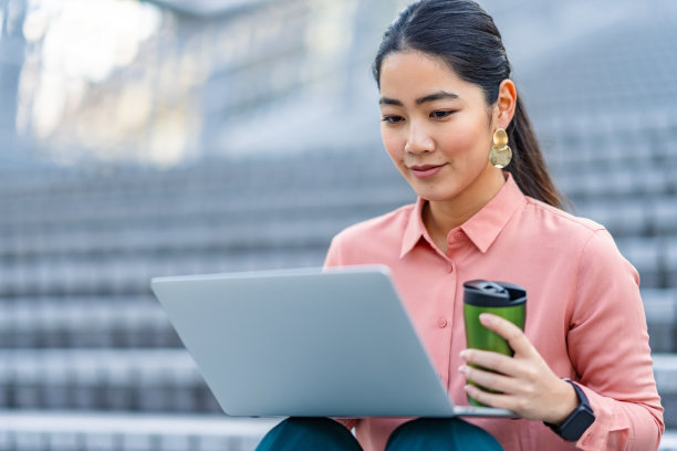 年轻漂亮时尚的亚洲女商人在城市使用笔记本电脑图片下载