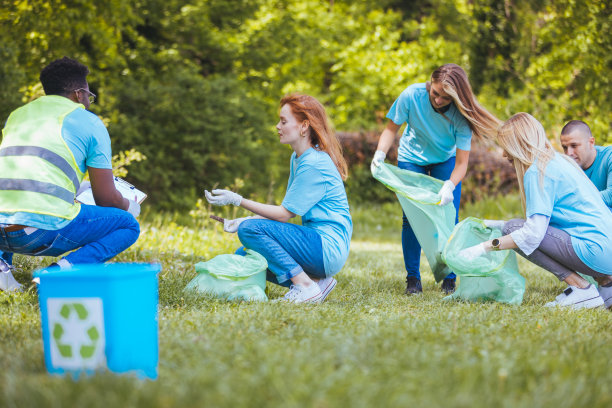 草地上的回收箱里挤满了迷离的志愿者图片下载