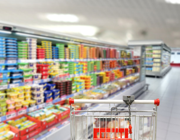 在超市挑选乳制品。空无一人的超市里的空购物车图片下载