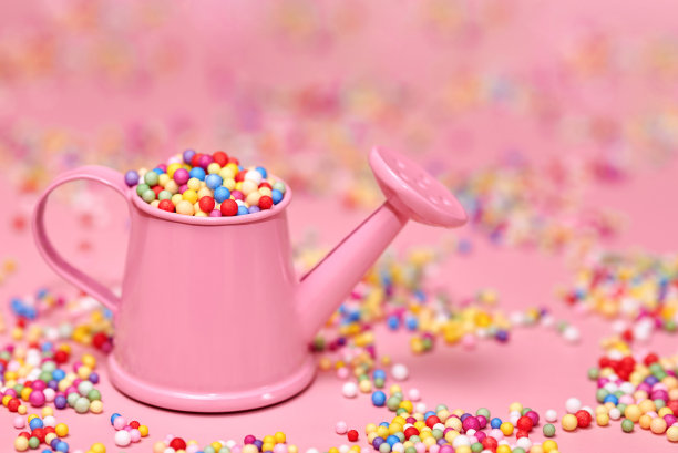 五颜六色的泡沫塑料小球装在一个微型水罐里。图片下载