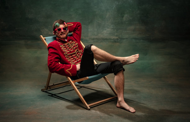 年轻男子的漫画肖像形象的中世纪骠骑兵日光浴孤立在古老的绿色背景。假日、假期、比较时代的概念。图片下载