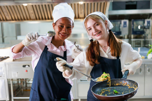 团体肖像年轻女子烹饪学生。烹饪课。烹饪教室。在一所烹饪学校，一群快乐的多民族女学生正在学习烹饪课程。图片下载