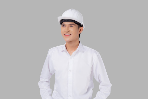 肖像年轻的亚洲男子是工程师戴着头盔站立和微笑自信孤立在白色背景，英俊的男子是建筑师或承包商，工人或劳工，工业概念。图片下载