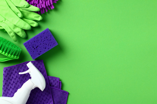 在绿色背景上平铺房屋清洁用品。平铺，俯视图。图片下载