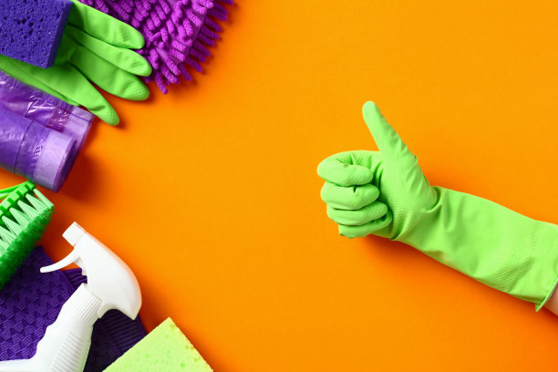 戴着绿色手套的专业清洁设备和用品大拇指朝上。清洁服务和客房服务理念。图片下载