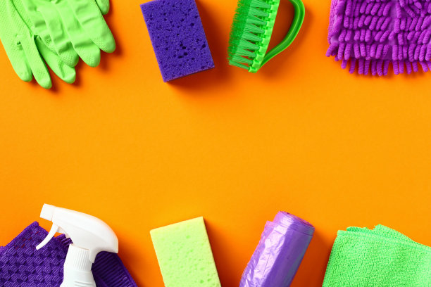 橙色背景的清洁工具和设备。平铺，俯视图。清洁服务或管家概念。图片下载