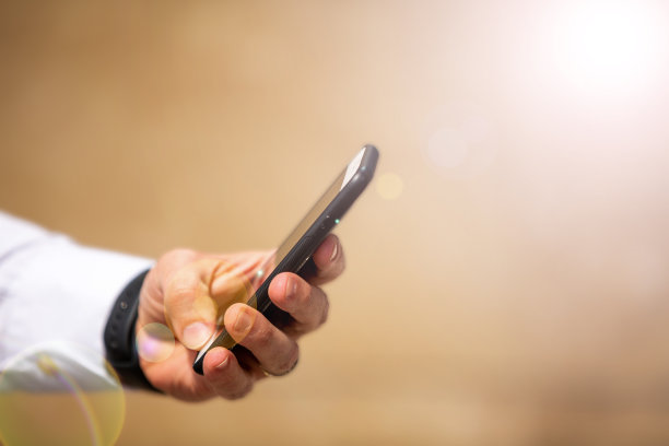 男性手持手机。空白的背景图片下载