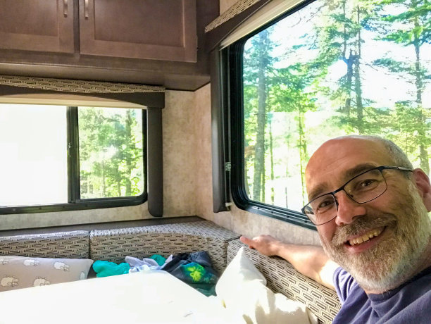 男人坐在车库里，窗外是大自然图片下载