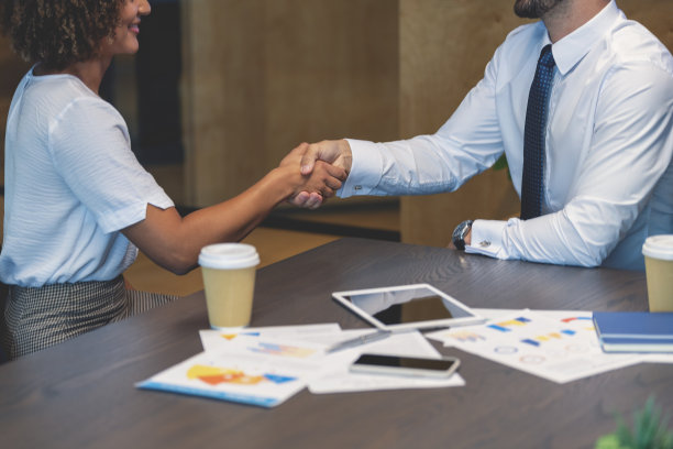 商务男士和女士在办公室握手。图片下载