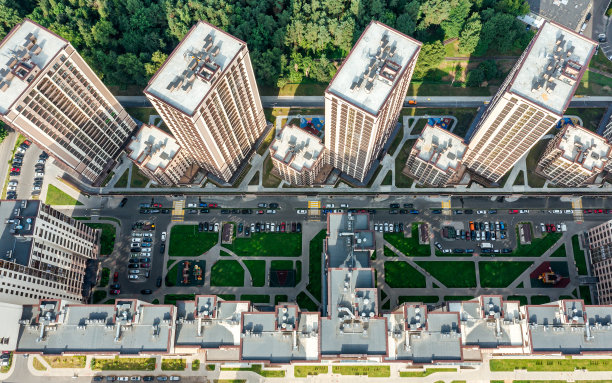 城市公园附近的公寓楼。院子里停着车。无人机俯瞰的照片。图片下载