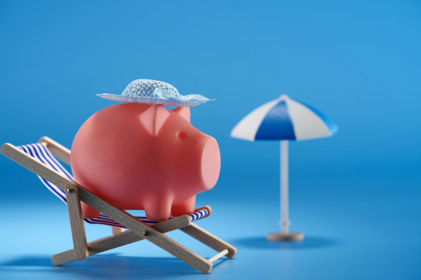 蓝色背景的沙滩椅上的存钱罐图片下载