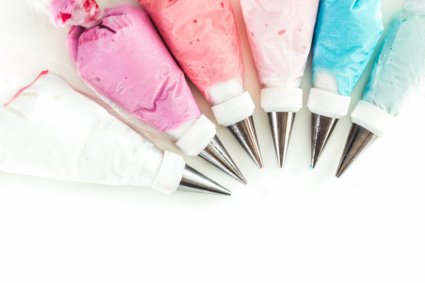 带喷嘴的糕点袋，白色背景上有五彩釉料图片下载